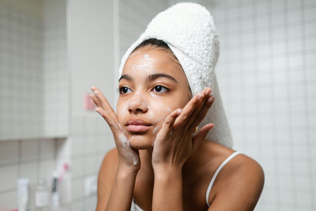 woman washing her face with cleanser